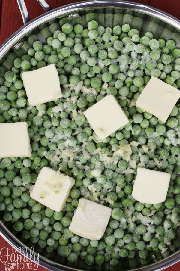Frozen Peas in a skillet with slabs of butter on top
