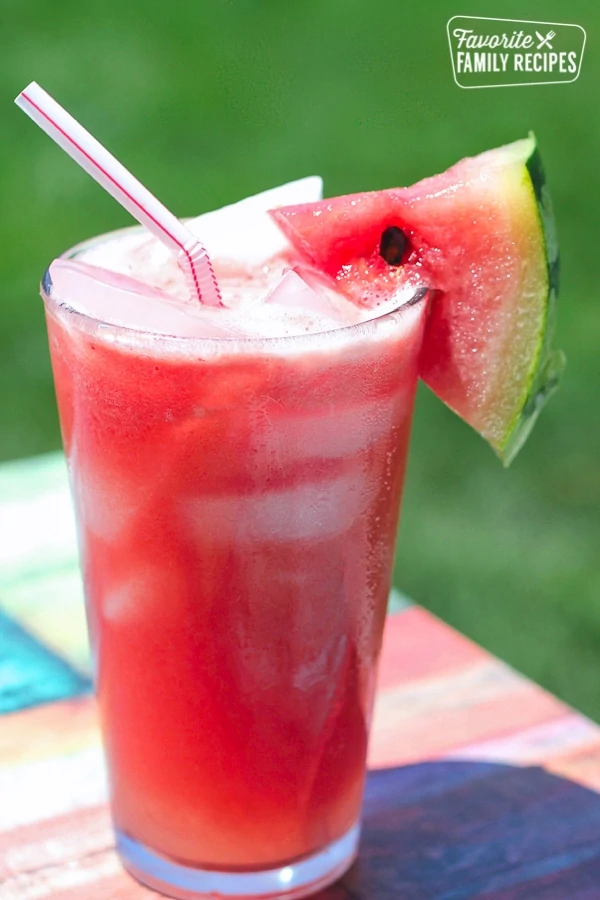 Ein Glas Melonade mit Strohhalm und Wassermelonenscheibe.