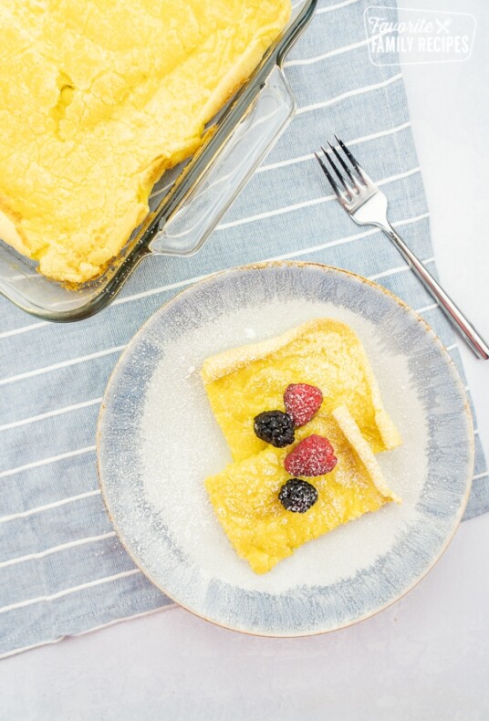 A plate of German pancakes with fruit on top.