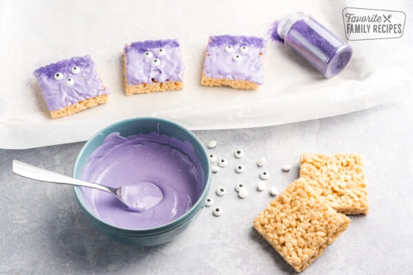 Rice krispies with purple frosting on them with three eyes on them.