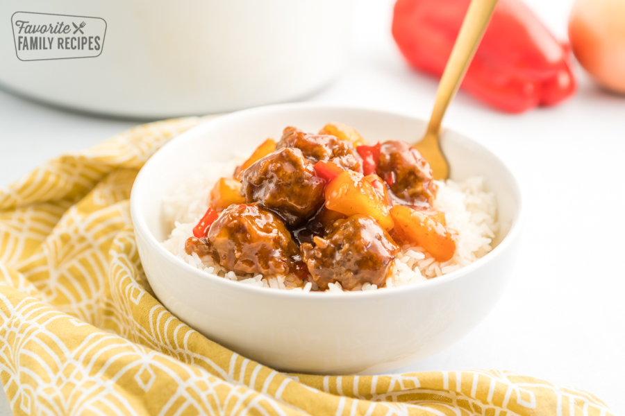 A bowl of rice topped with sweet and sour meatballs