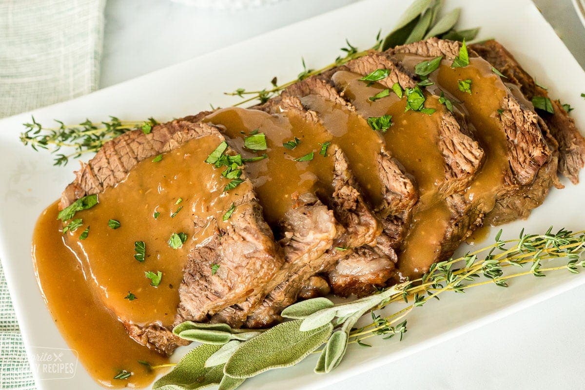 Roast beef made in the oven that has been sliced and on a plate.