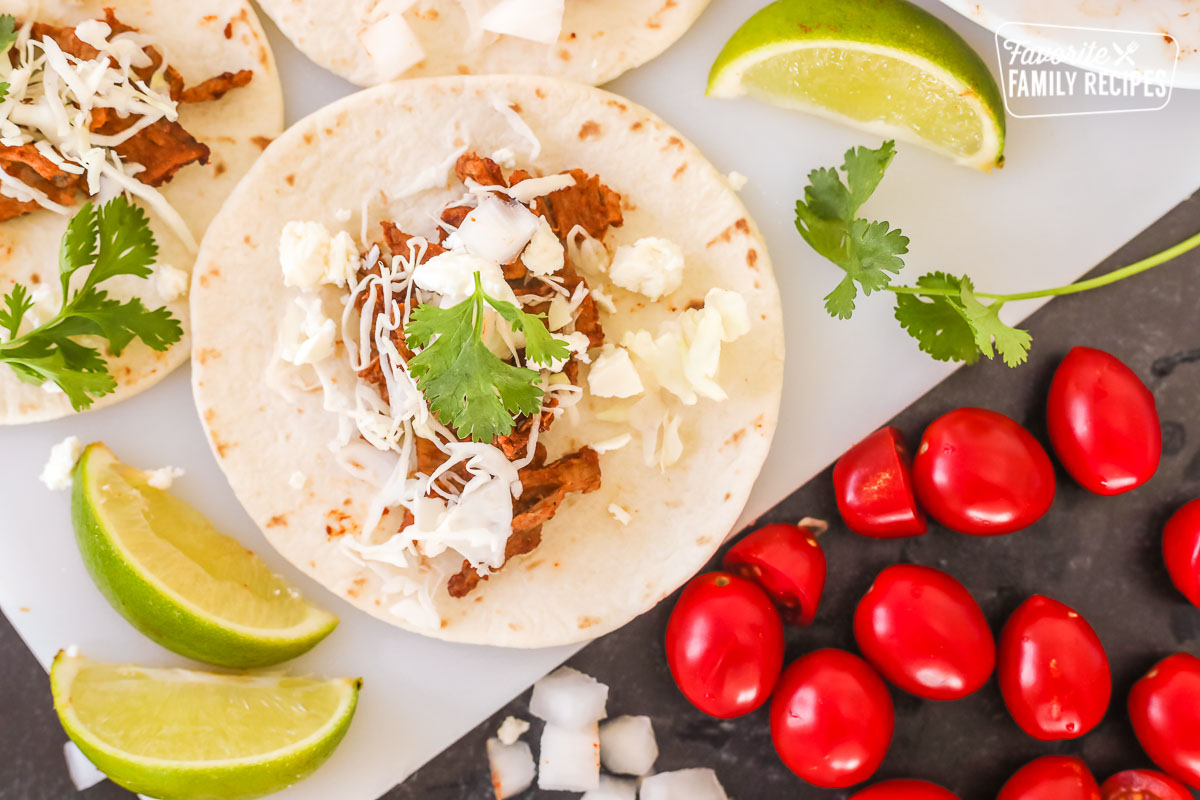 Top view of a taco made with steak, shredded cabbage, cilantro, and cheese.