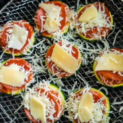 Uncooked zucchini pizza bites on an air fryer rack