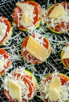 Uncooked zucchini pizza bites on an air fryer rack