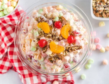 Classic ambrosia fruit salad topped with orange slices, maraschino cherries, and pecans