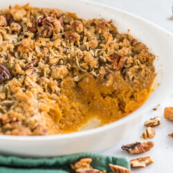 Side view of a sweet potato casserole with a scoop taken out