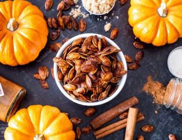 Pumpkin seeds that have been roasted in a sweet and spicy mixture in a bowl