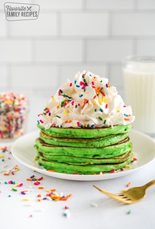 Stack of Green Pancakes for St. Patrick's Day with whip cream and rainbow sprinkles