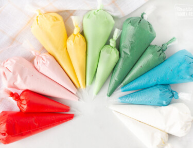 Red, pink, yellow, light green, dark green, blue and white bags of Royal Icing.