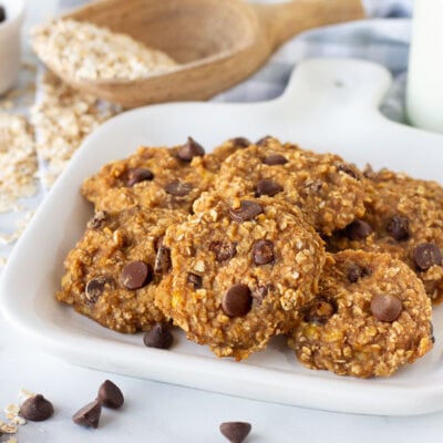 Close up of a plate of Healthy Oatmeal Cookies. Milk, oats and chocolate chips on the side.