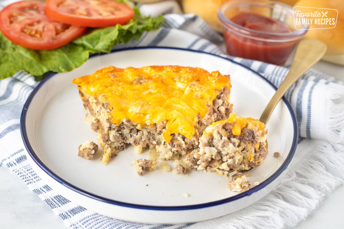 Plate with a slice of Cheeseburger Pie and fork with a bite of pie.