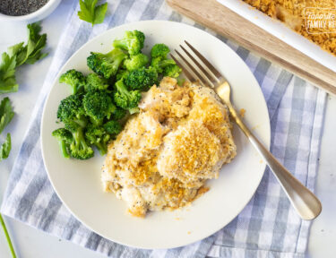 Plate of Poppy Seed Chicken with cooked broccoli and a fork.