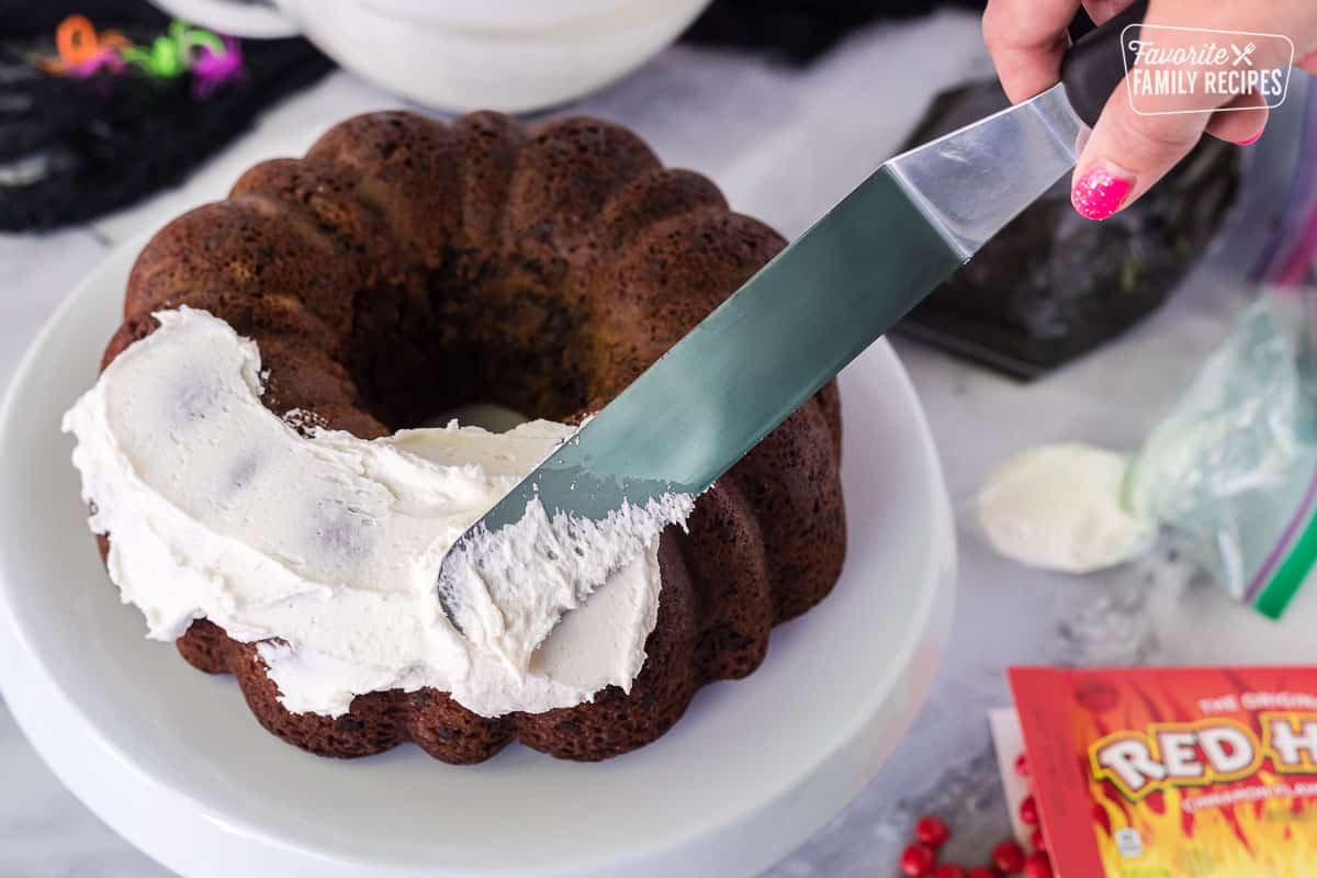 Frosting the bundt cake for Spider Cake.