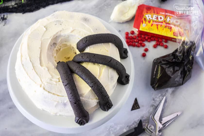 Four spider legs on frosted bundt cake.