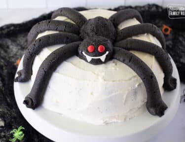 Spider Cake on a Cake stand with fang smile and Red Hot eyes.