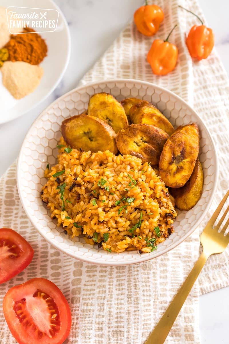 Jollof rice in a bowl with fried plantains.