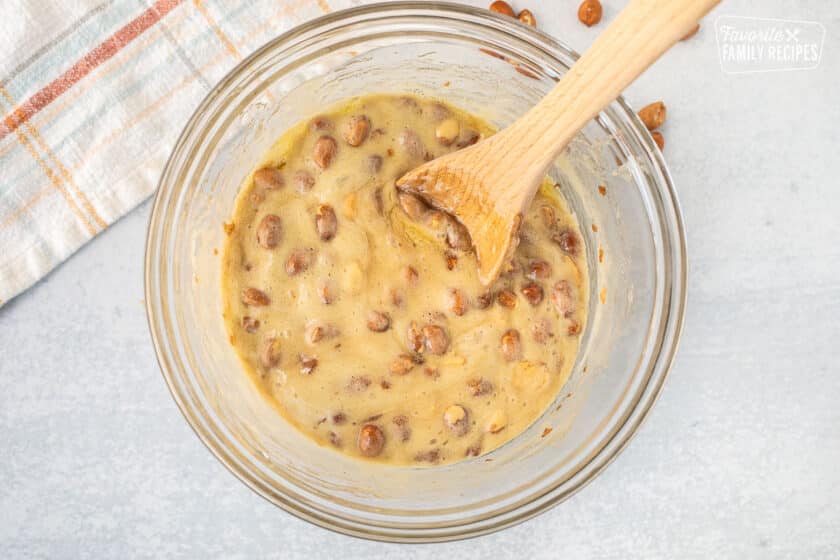 Mixing bowl with fluffy peanut brittle and wooden spoon.