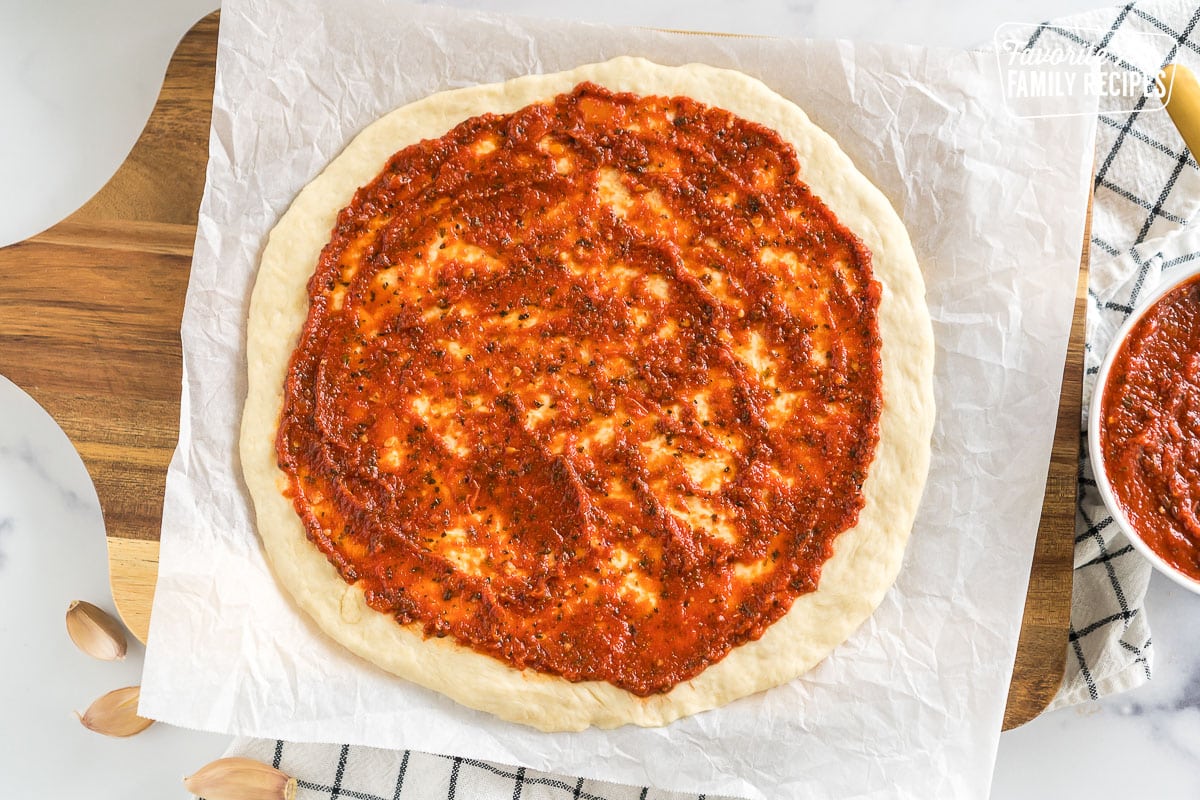 Pizza dough topped with red sauce