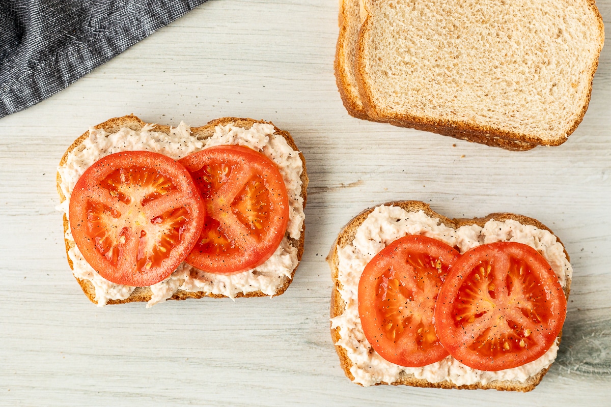 Sliced wheat bread with albacore tuna and sliced tomatoes.