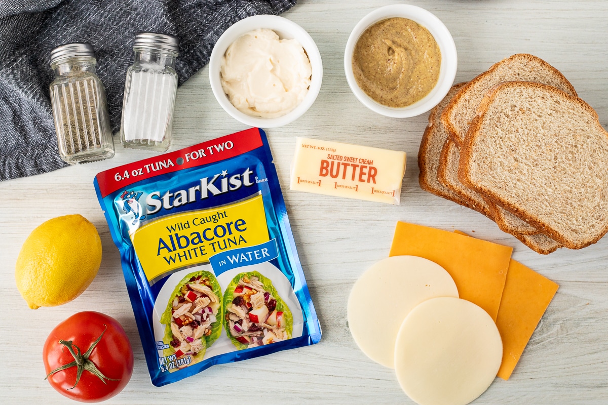 Ingredient to make a Tuna Melt including albacore tuna, mayo, dijon mustard, wheat bread, sliced cheddar cheese, sliced provolone cheese, butter, tomato, lemon, salt and pepper.