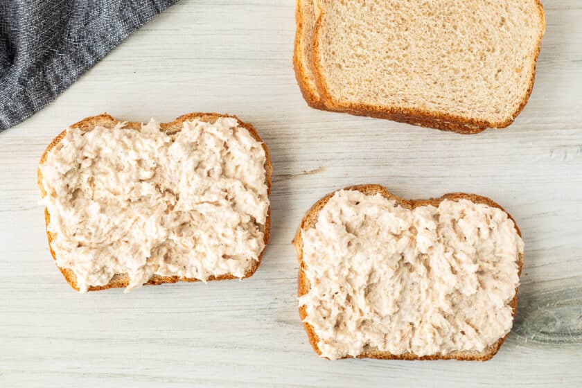 Two slices of wheat bread with tuna mixture on top.