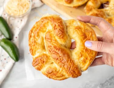 Hand holding a Jalapeno Cheese Stuffed Pretzel.