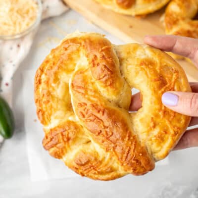 Hand holding a Jalapeno Cheese Stuffed Pretzel.