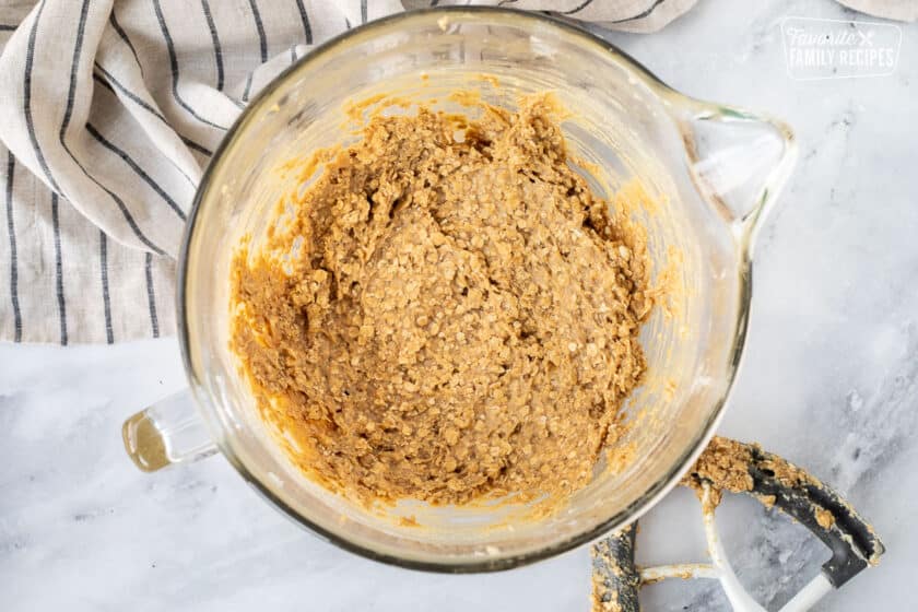 Mixing bowl with eggs and oats in cookie dough mix.