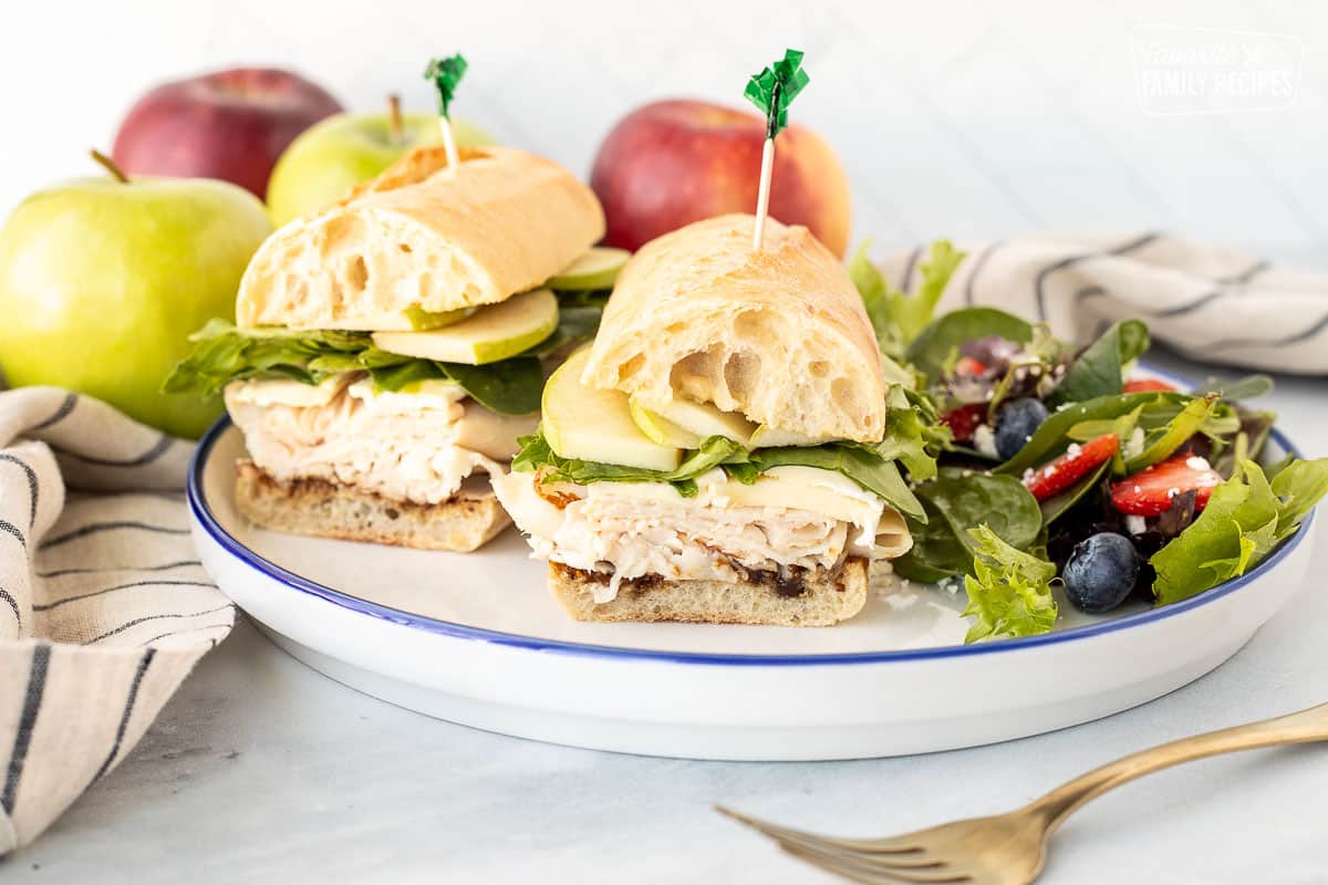 Inside view of Turkey Sandwich with Brie Cheese and Apples on a plate with a side salad.