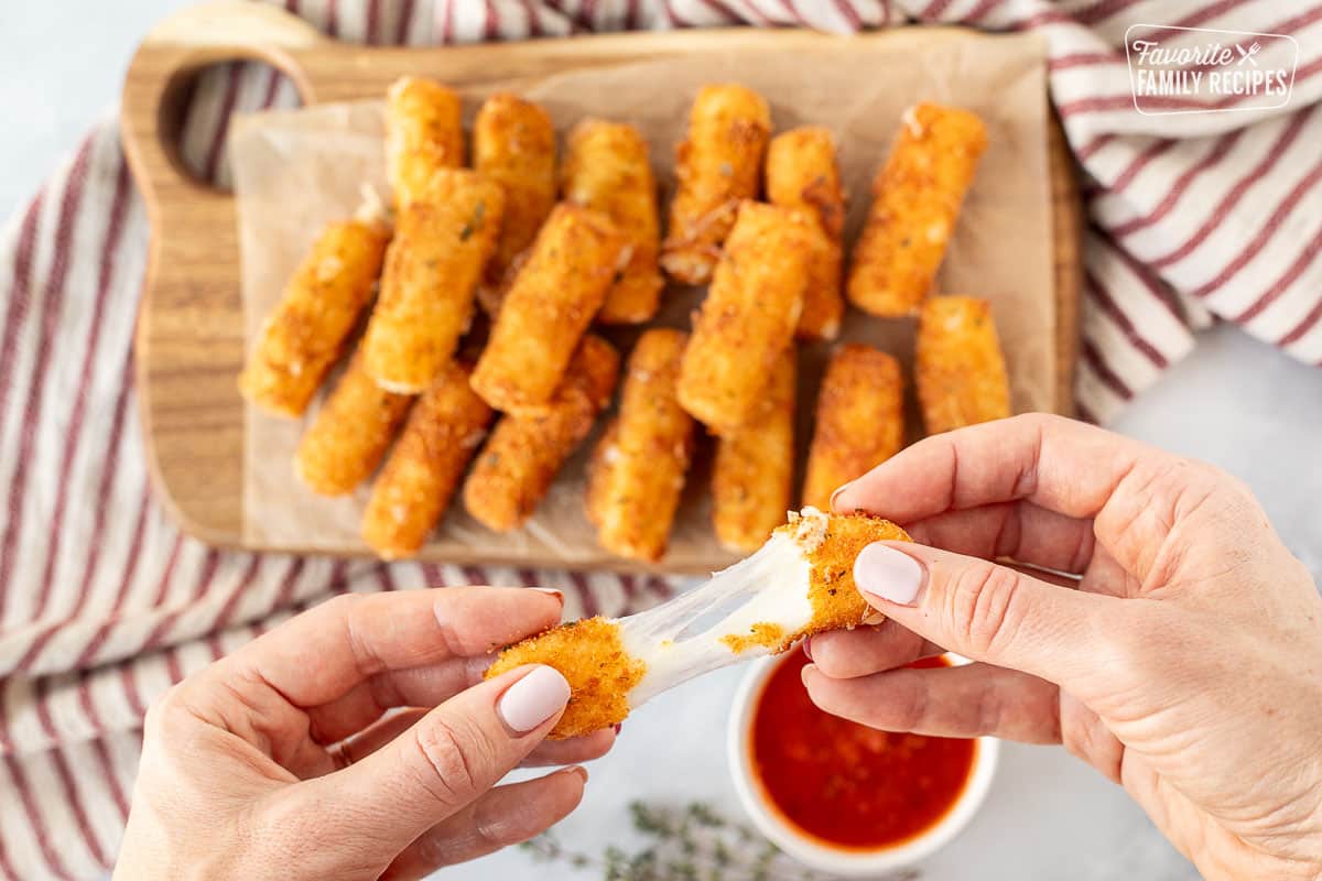 Stretching Homemade Mozzarella Sticks cheese with hands.