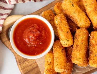 Cup of marinara sauce with Homemade Mozzarella Sticks.