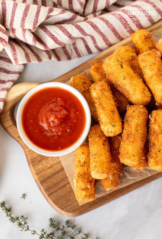 Cup of marinara sauce with Homemade Mozzarella Sticks.