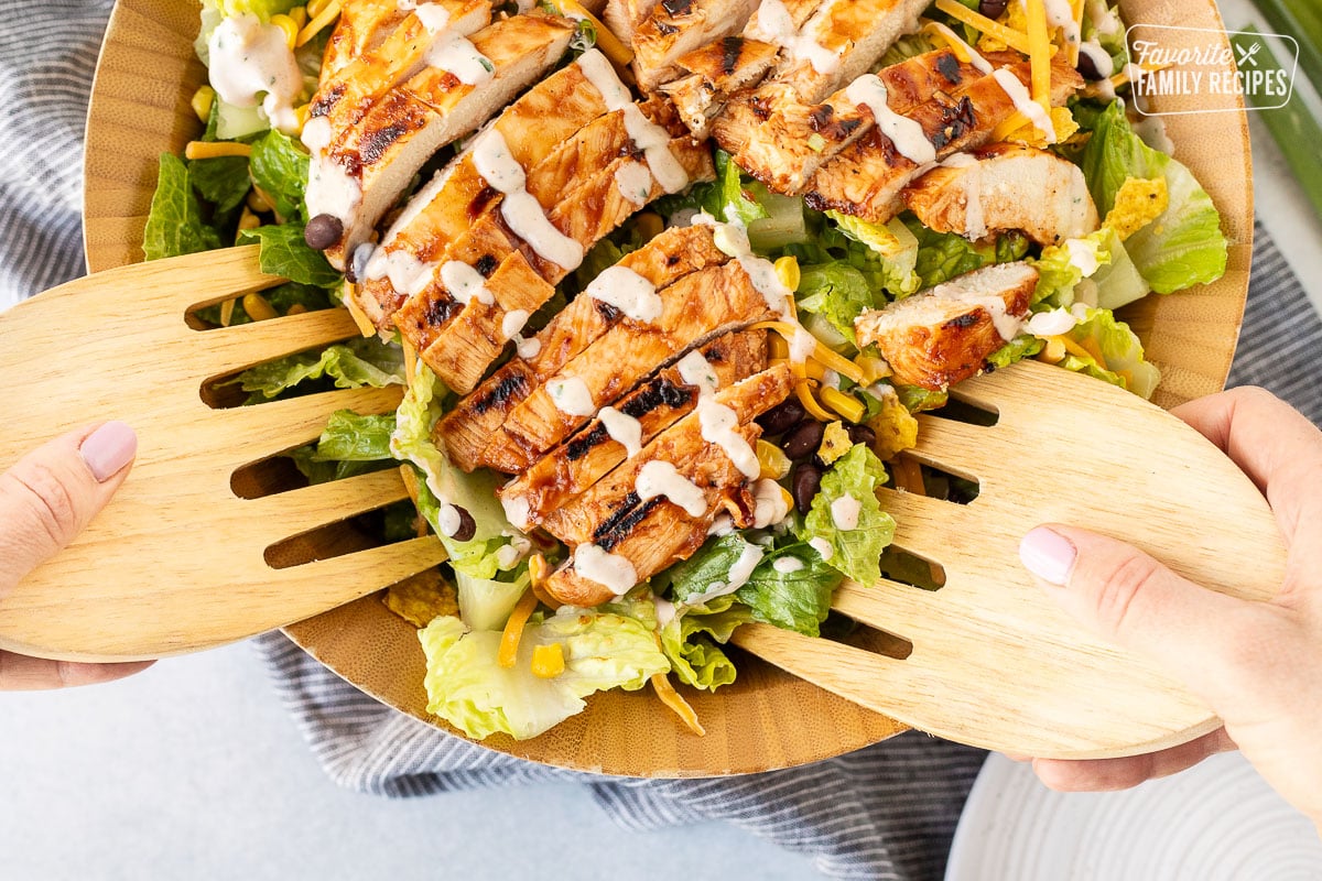 Tongs grabbing a serving of Barbecue Chicken Salad.