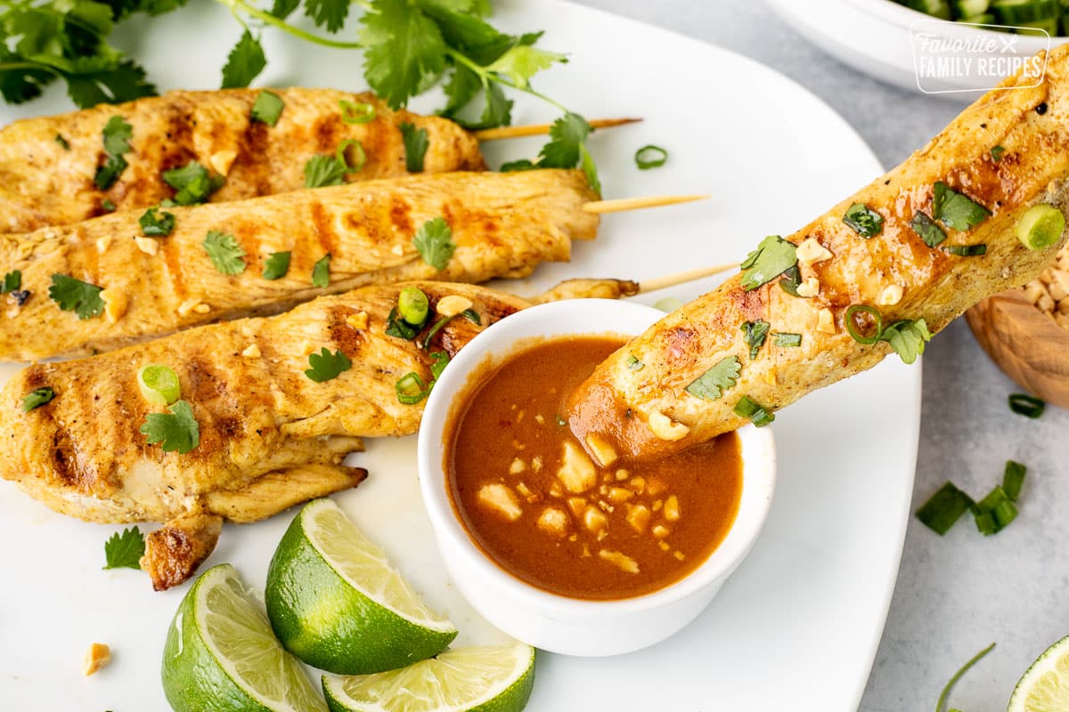 Dipping Chicken Satay into peanut sauce.