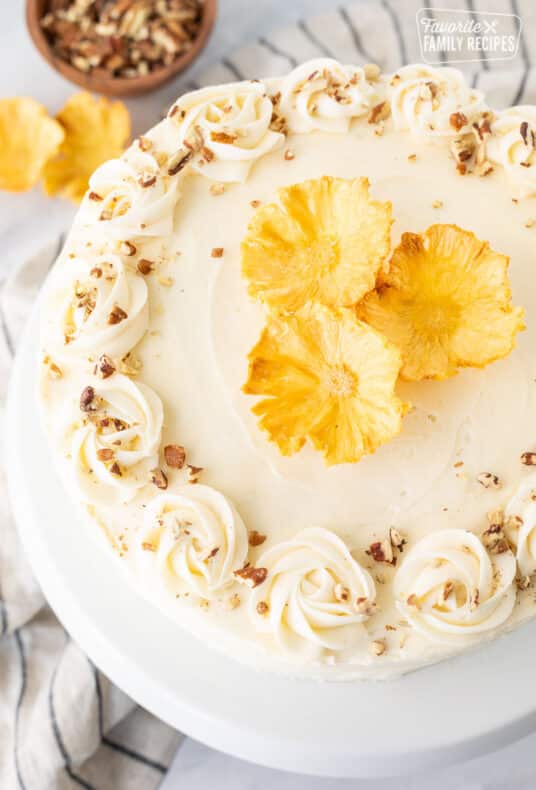 Hummingbird Cake topped with dried pineapple flowers and chopped roasted pecans.