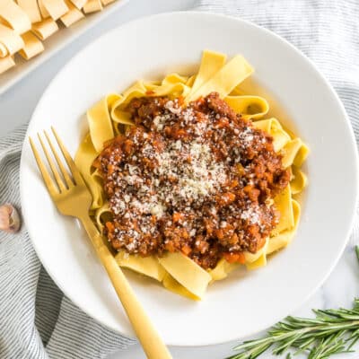 A bowl of Pappardelle Bolognese topped with parmesan cheese