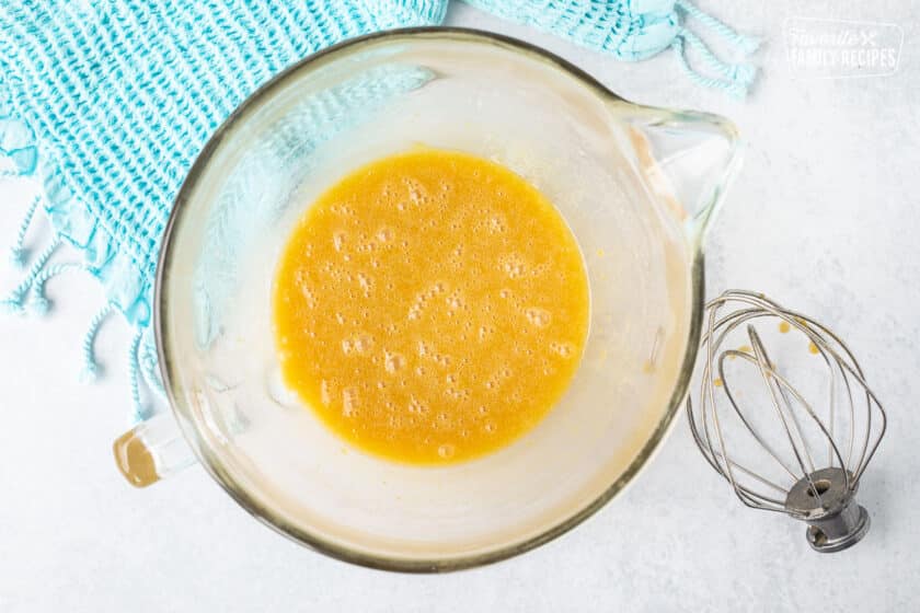 Glass mixing bowl with wet ingredients combined. Whisk attachment on the side.