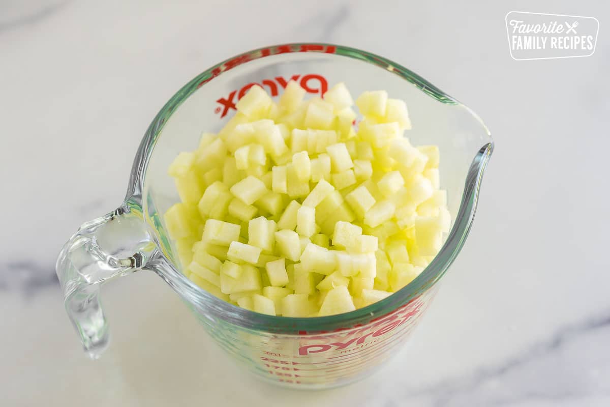 diced apples in a measuring cup