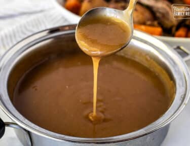 Ladle of Beef Gravy pouring into saucepan.