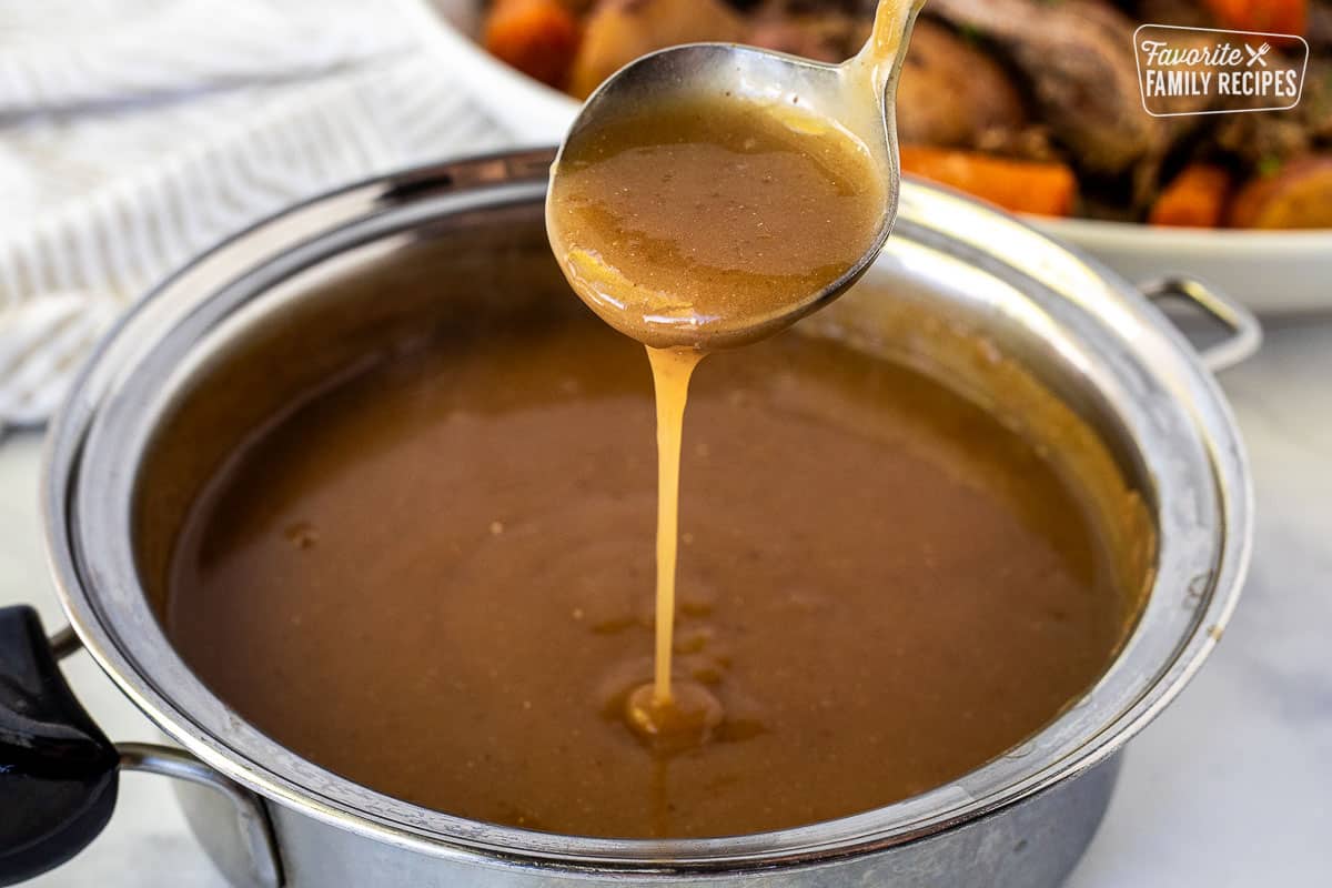 Ladle of Beef Gravy pouring into saucepan.