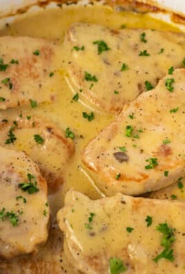 Close-up of melt-in-your-mouth pork chops in a crock pot with savory gravy.