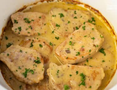 Crock Pot Pork Chops cooked in a white crockpot.