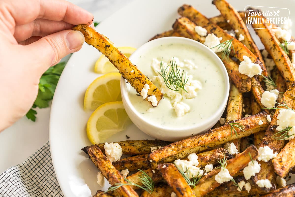 A fry being dipped in feta dip