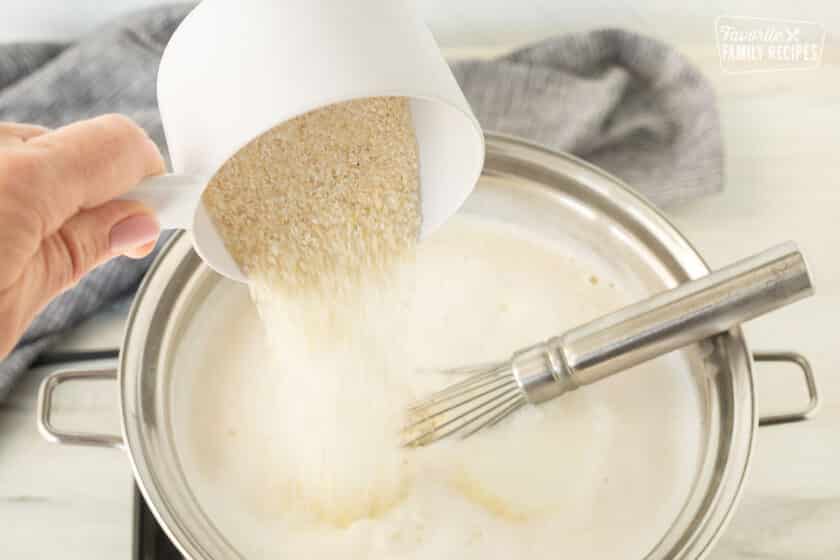 Pouring Grits into boiling saucepan.