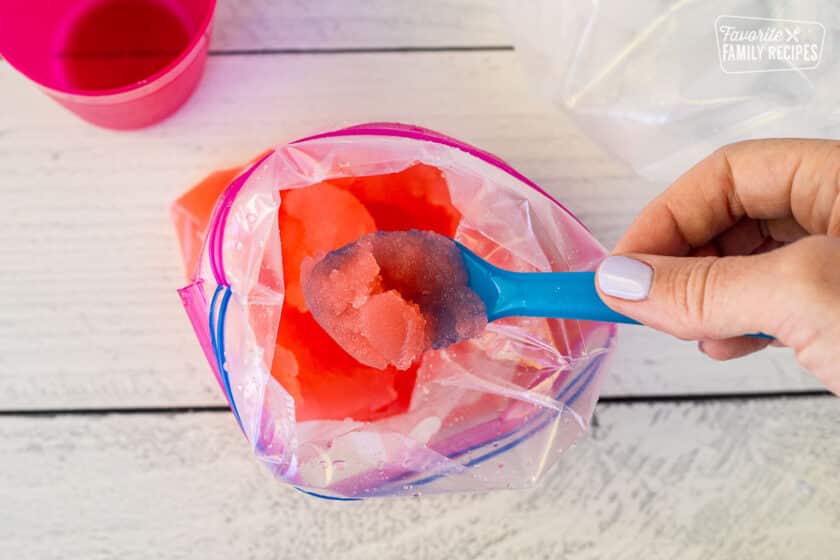 Spoon with a scoop of homemade pink slushie.