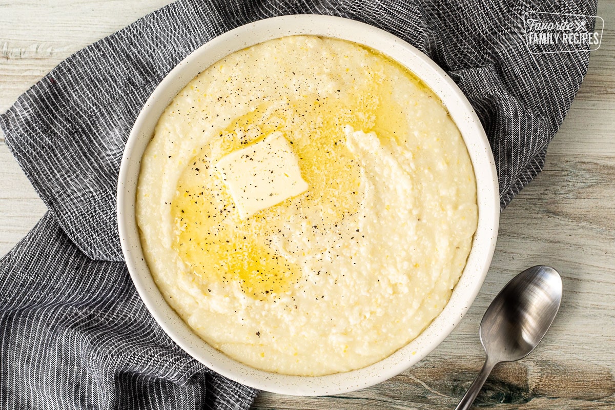 Bowl of Grits with butter and pepper. Spoon on the side.