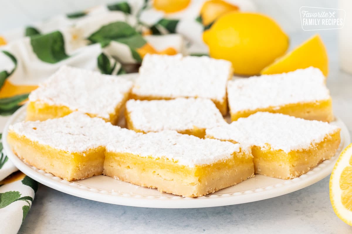 Cut Leon Bars on a glass plate. Sliced lemons on the side.