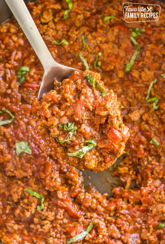 A scoop of meat sauce on a metal spoon