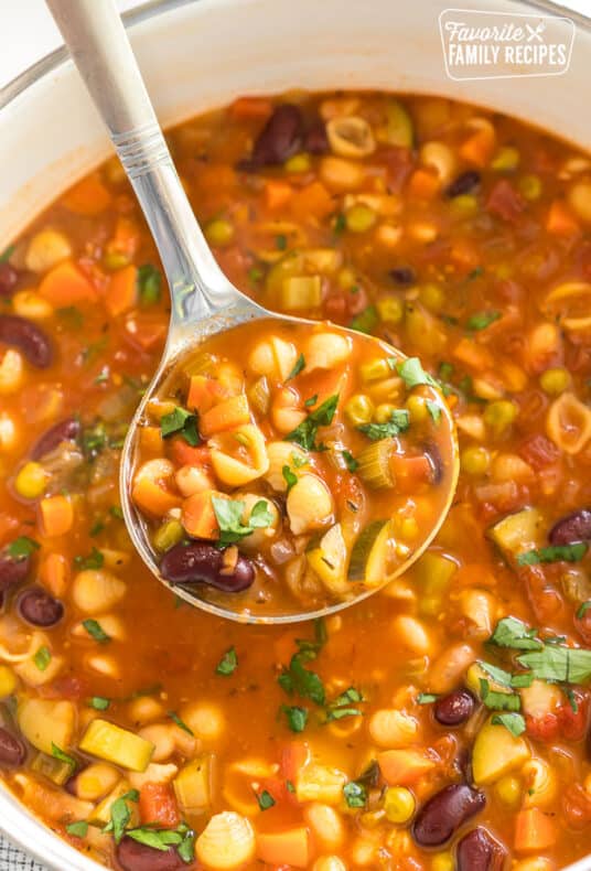 A ladleful of Minestrone soup from a pot